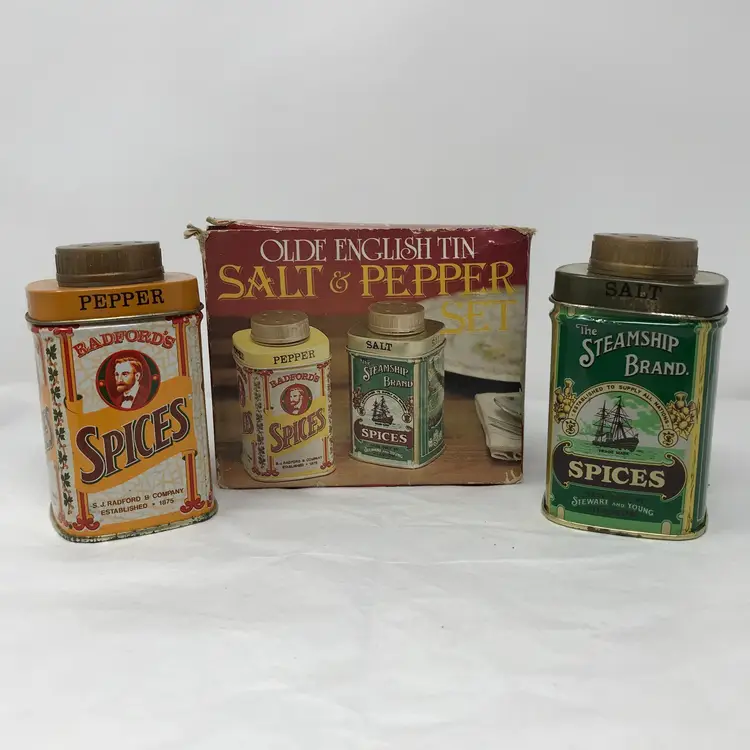 Olde English salt and pepper shakers in original box. Metal with plastic screw-on tops. Made in Hong Kong. No scratches or dents, never used. Minimal corrosion at base of both shakers. Some wear on box. Shakers 3.5 H x 2 L.