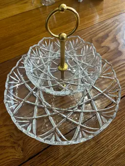 Vintage  Made in Germany Mikasa Roxborough 2 Tier Center Handle TidBit Tray Plate
Bottom Plate is 12 3/4" in Diameter.
Top Plate is 6 1/2" in Diameter.
9 1/8" Tall Overall. 
two-tier glass tidbit tray with a gold-toned handle.
