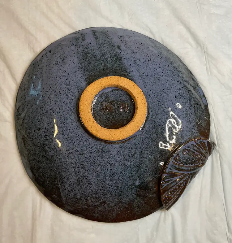 #01 Handmade pottery plate, 10” round, beautiful bluish purple glaze, with a unique folded piece that adds a wonderful touch. Initialed with JS 14