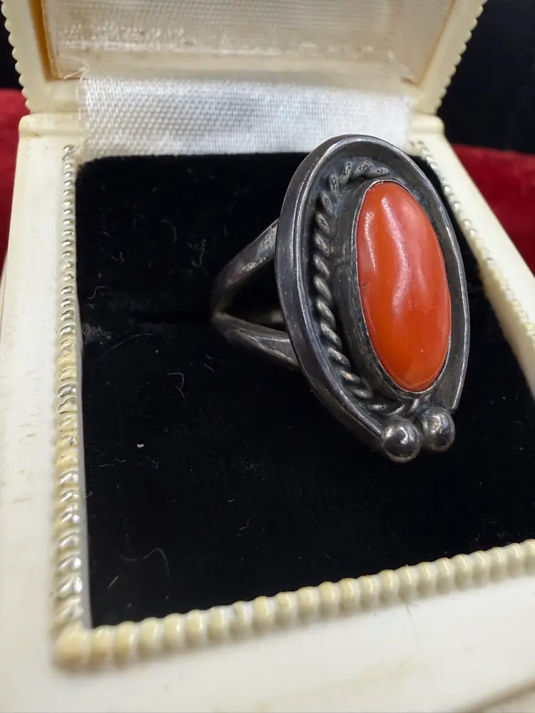 vintage Native American Navajo sterling silver ring featuring a natural red coral cabochon stone.