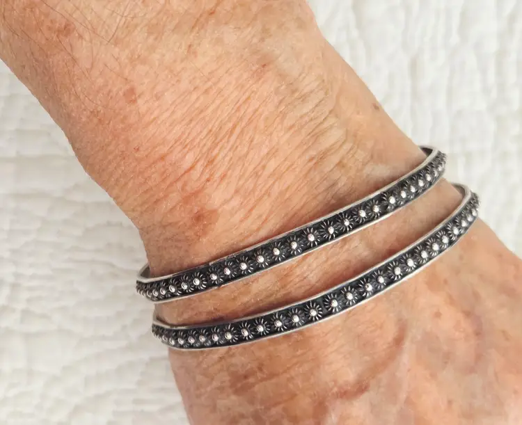 Pair of Vintage Signed Mexican Sterling Silver Bangle Bracelets with an Embossed Petite Floral Design
