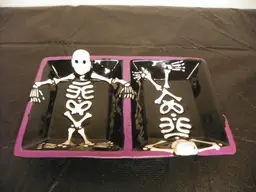 Halloween decorative candy dish featuring two skeletons