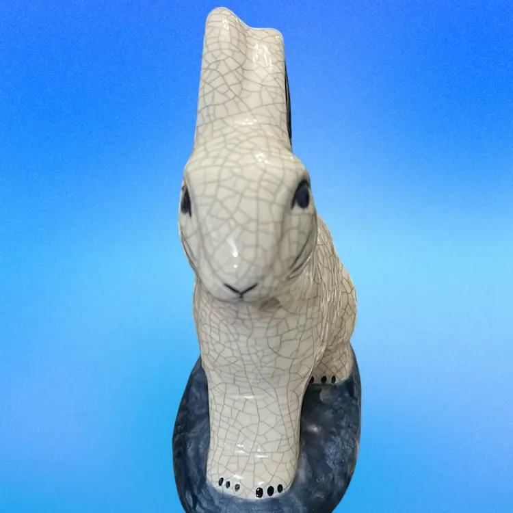 A Dedham Pottery rabbit figurine with blue crackle glaze and floral accents. Make Your Own Cotton Tail, Signed