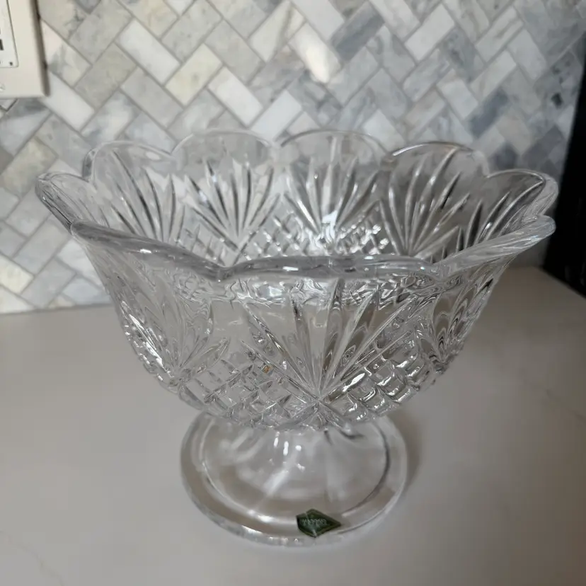 A clear cut Shannon crystal footed trifle bowl with a scalloped rim.