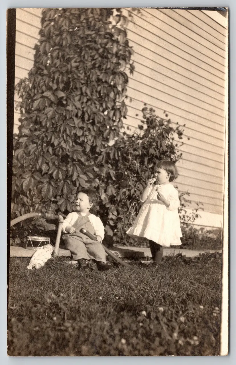 Postcard RPPC Children with Hose and Toy Doll Real Photo Girl Eating - 9221