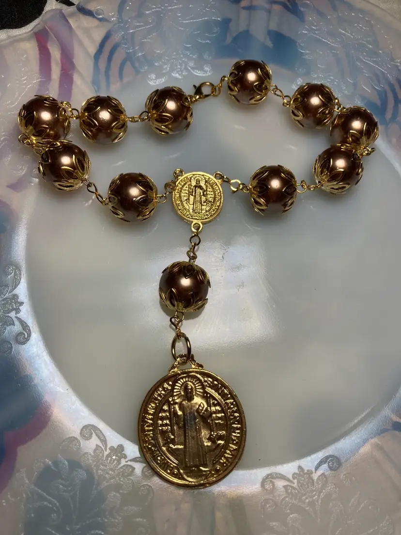 Bracelet Rosary
Large Metal Bronze Tone Beads with Ornate Brass Covers.  
Brass Crucifix & Jesus. 
Lobster Clasp. 
They Call It A Bracelet Rosary But It Seems Bigger Than a Bracelet. 
Collectable