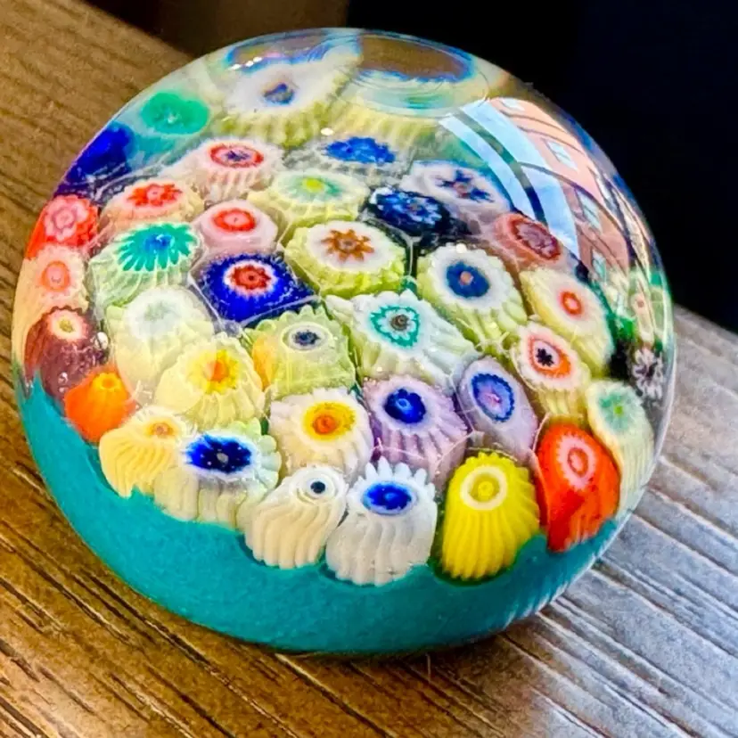 GLOWS GREEN. Art Glass Italian Millefiori Murano Paperweight, teal blue base & multicolored floral canes 1960s. 1.5x1.75”