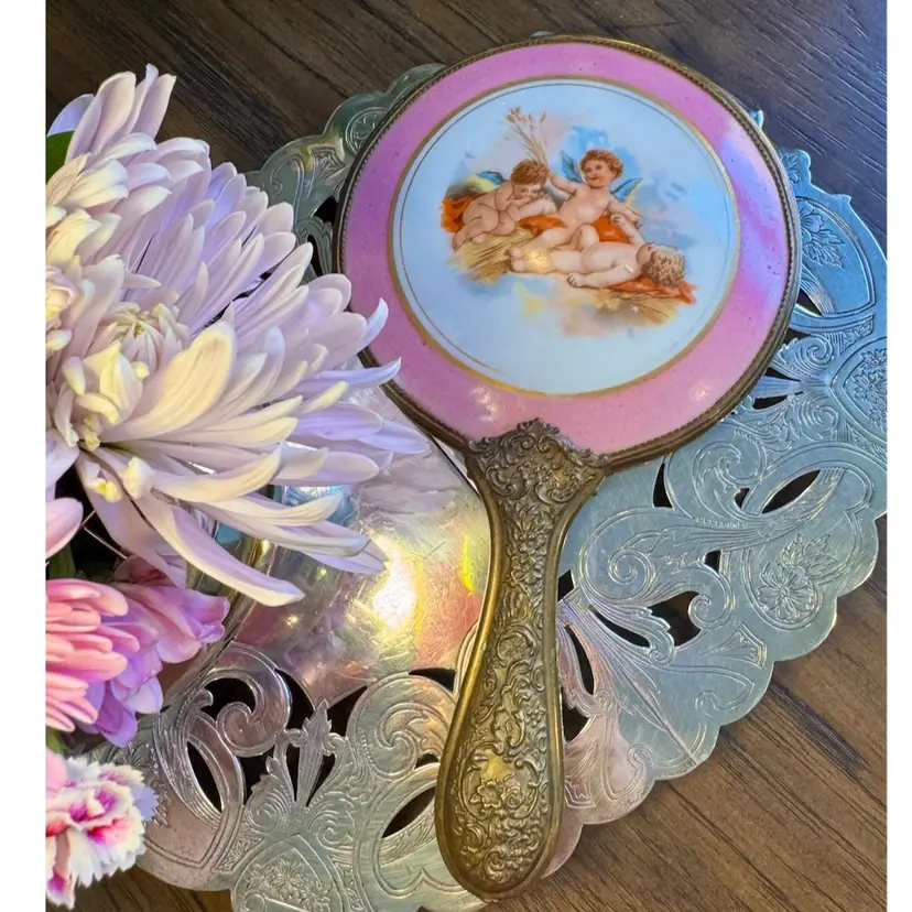 9x5” antique 1880-1920
hand mirror w/pink porcelain w/putti/cherubs & ornate brass handle