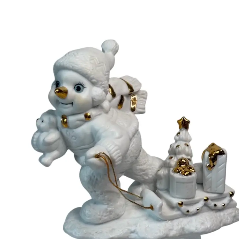 White Porcelain Snowman Figurine Grandeur 2000 Snowman Sled Teddy Bear Toys 
5” T x 6” L x 3” W