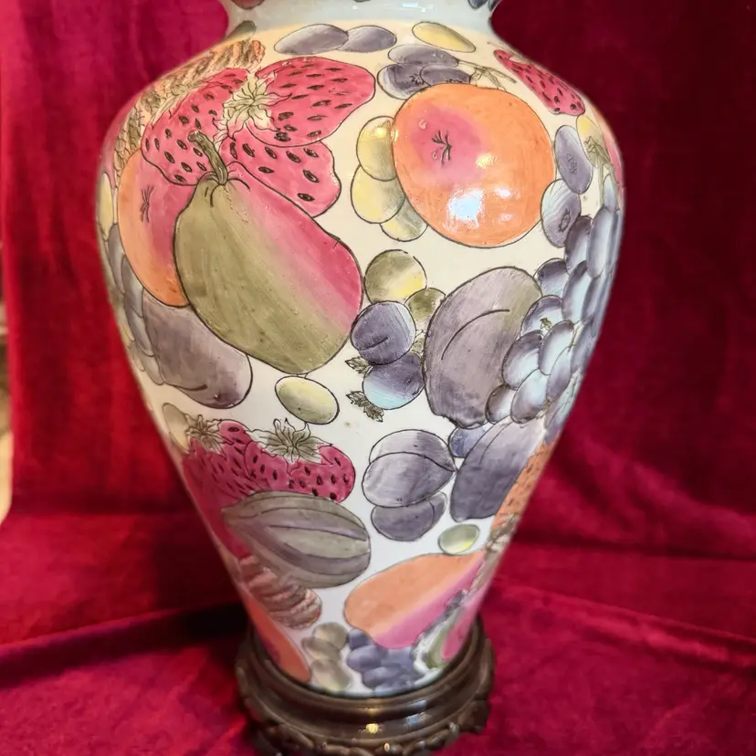 Gorgeous vintage Chinese Chinoiserie porcelain mantel urn vase with a fruit pattern finish and Carved base. Approximately 12” Tall with base and 23” Around.