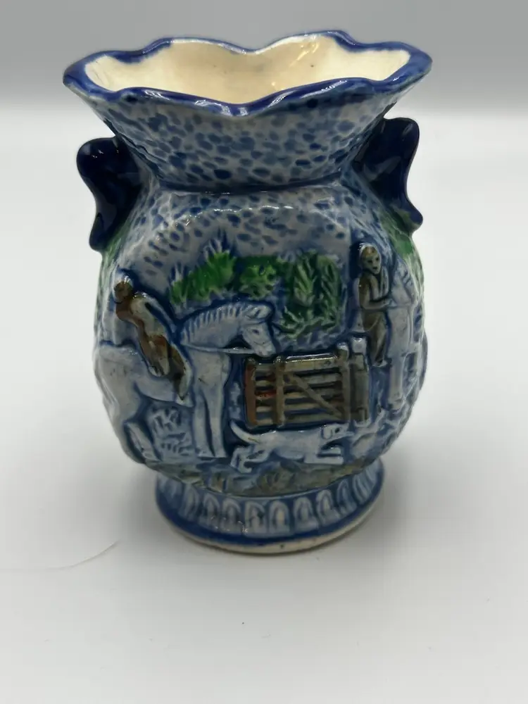 A14 A vintage Japanese porcelain vase with a raised hunting scene.