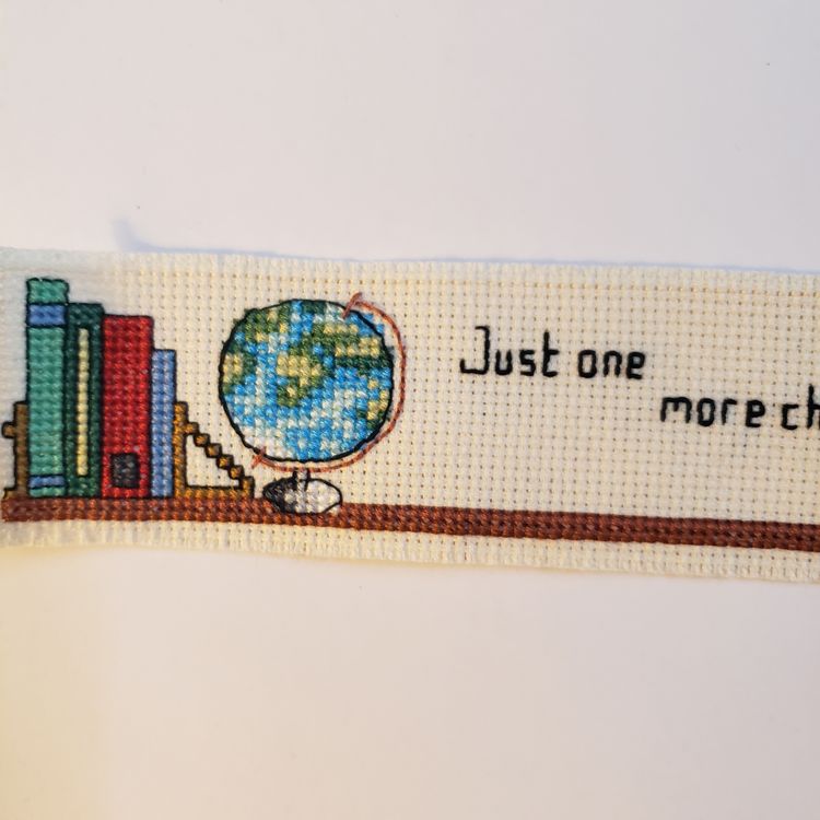 New Cross-stitched bookmark "Just One More Chapter"  on ivory Aida cloth.