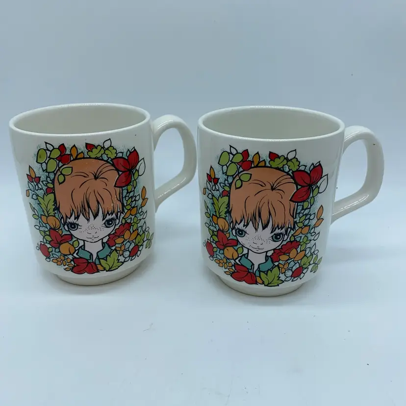 #1709 A pair of Lord Nelson England ceramic mugs with a big-eyed girl illustration.
