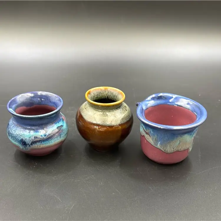 A set of three pottery dishes, too many vases and one creamer