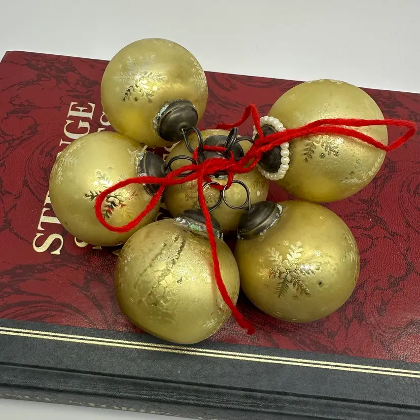 Vintage Gold Glass Ornaments On A Decorative Book (Strange Stories Amazing Facts)