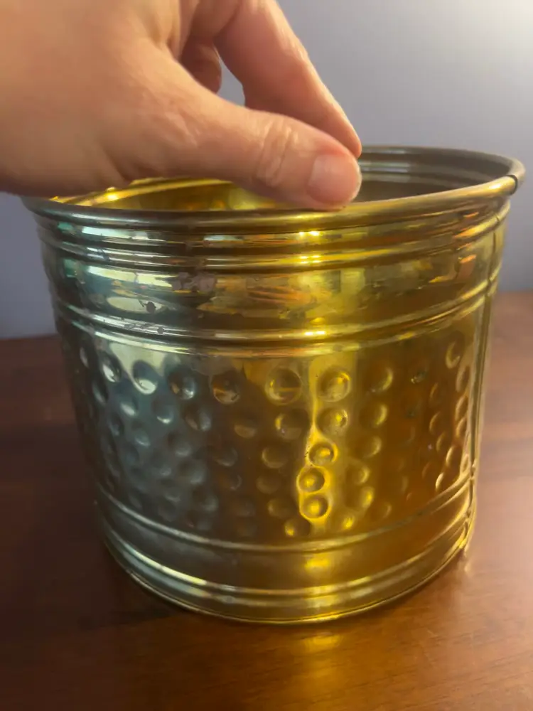 Vintage hammered brass planter with a rolled rim and decorative bands.
Nearly 7 Inches Tall And 8 Inches Wide