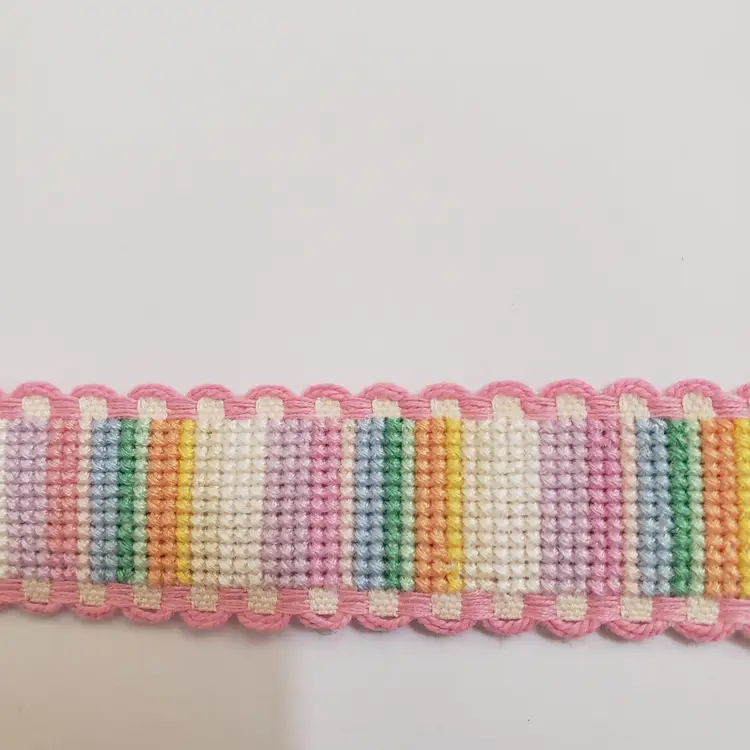 New Cross-stitched multi colored striped Ribband with pink trim.