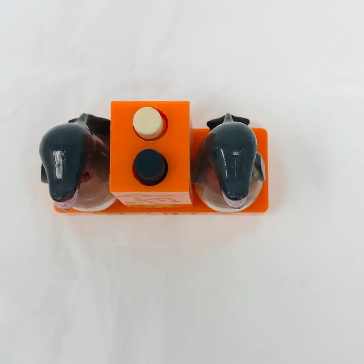 Whirley MCM push-button salt and pepper shaker. Souvenir of Virgian Beach, VA. Orange base with black dolphins and gold color details. Plastic. Please see photos. 2.3 H x 3 L x 1.25 W