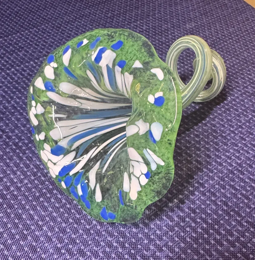 blown glass flower with a speckled green, blue, and white color, curly stem 7”