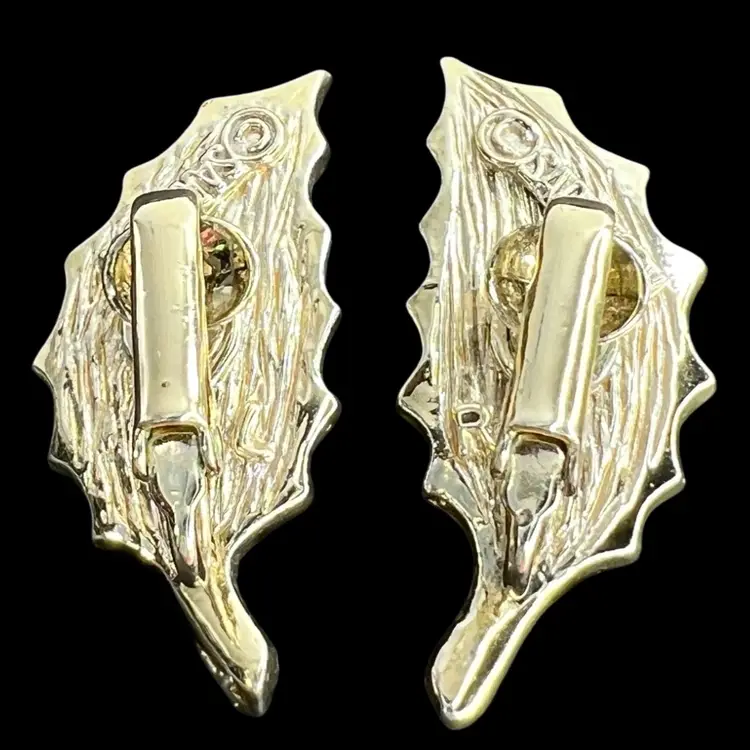 1960s Sarah Coventry 
Clip On Earrings. Scalloped Leaves in Gold-tone with faux Wood Grain Inset. Signed “SARAHCOV”.