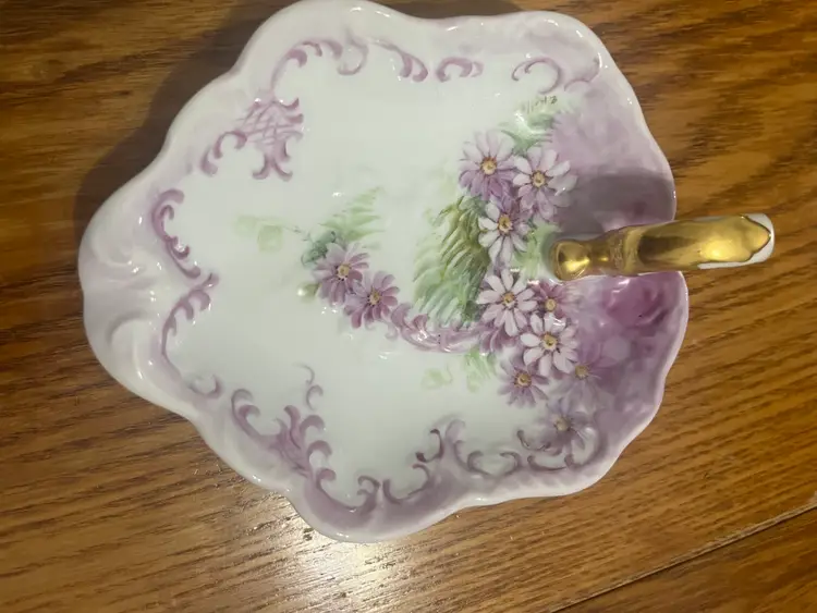 Hand-painted porcelain trinket dish with floral motif and gold handle. 6 inches.