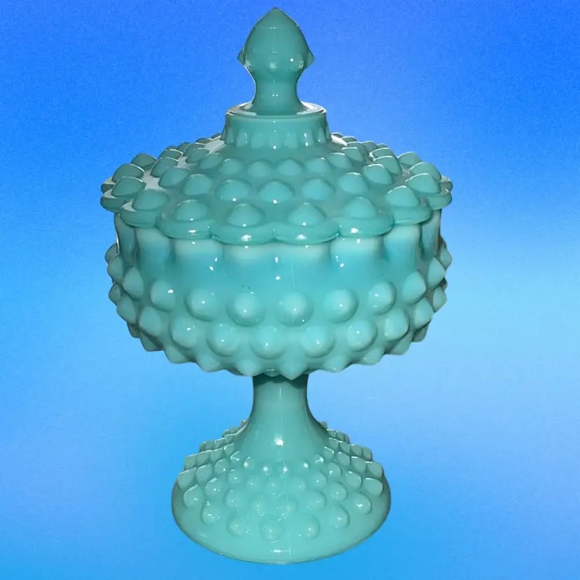 This is a vintage Fenton turquoise hobnail compote with a lid, likely from the 1950s. 6”tall Without Lid. 2.5”lid,5” Wide