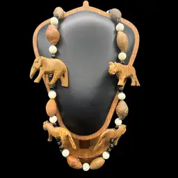 vintage African necklace featuring hand-carved wooden safari animals and mixed material beads- Onyx And MOP?.
