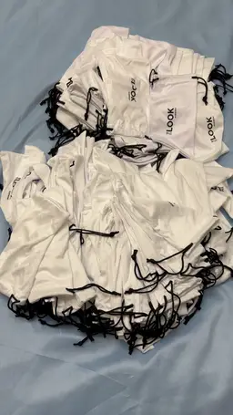 200 Drawstring Cloth Eyeglass Cases. Some Are Bright White While Others Are More Off White