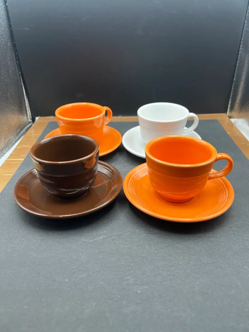 #913B Set Of 4 Fiesta Ware Cups And Saucers
2 Tangerine, 1 Chocolate, 1 White