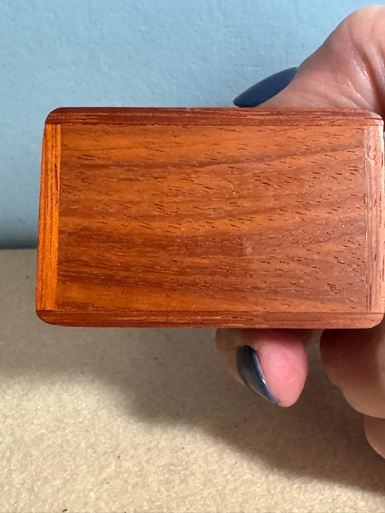 Marquetry inlaid wooden trinket box with a sledding figure
