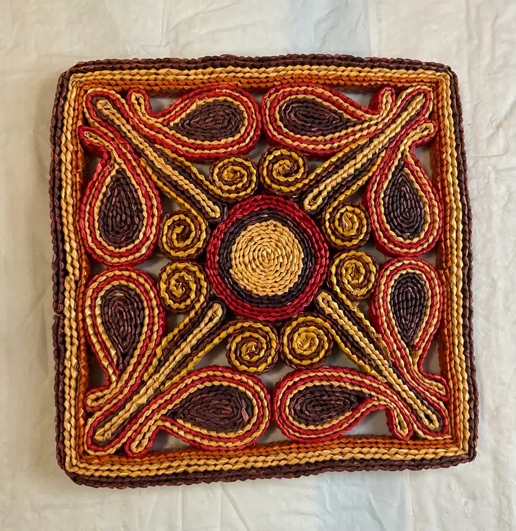 Straw woven trivet 7 1/4” square, red, orange, yellow, burgundy