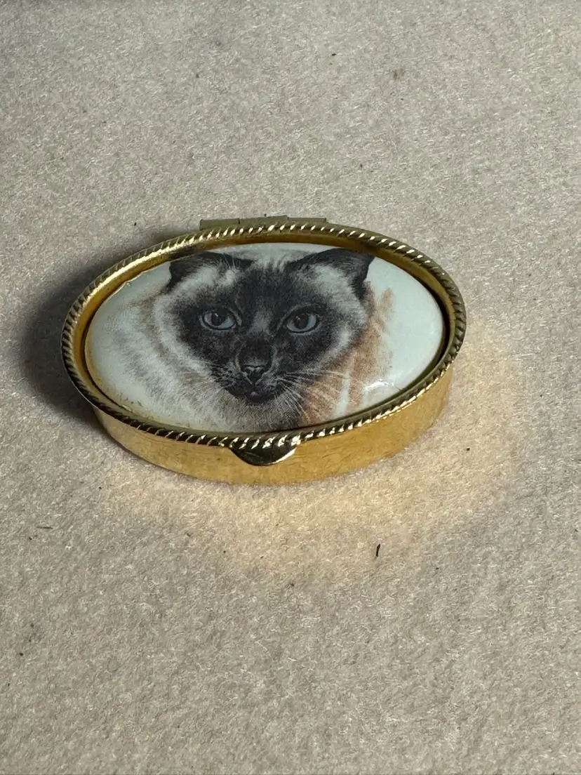 Vintage brass pillbox with a ceramic Siamese cat lid