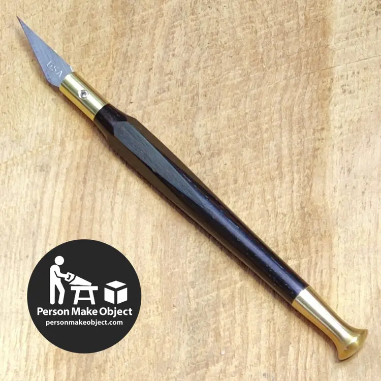 Ebony and brass "RX11" xacto-ish knife. Holds xacto no11 and similar blades. 
Brass hardware and handle made by me from scratch in my basement shop. Hexagonally faceted contoured handle (modeled after my favorite vintage xacto knife) feels great in the hand, lends detail control, and won't roll off your bench. The brass blade wrench snaps onto a rare earth magnet embedded in the handle with a satisfying click! 
Includes assortment of blades, storage tube, and some stickers and stuff. 
100% Satisfaction Guarantee – If the product does not meet your expectations, return it in lightly used condition for a full refund.
Lifetime Warranty – If the product should fail due to defect in material or workmanship before the I die or am incapacitated, return it for repair or replacement.
I have some others on hand in a variety of materials and configurations and I build to order - message me for more info.