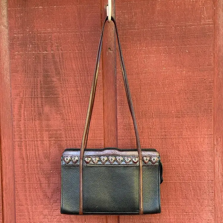 Brighton Purse / Bag C606859. Pebbled Black Leather With Brown Leather Straps. Motif Of Brown Leather Hearts With Metal Heart Accents. Zipper Has Black Leather Heart Pull. Three Interior Compartments, Which Include a Zipper Coin Pocket, Pen & Card Holders (?), and a Key Clip. Exterior Compartment Has Clear ID Or Card Holder, Plus Slots For 8 Additional Cards. 10”w x 6”h x 2.75”d (5.5” Opening at Top).