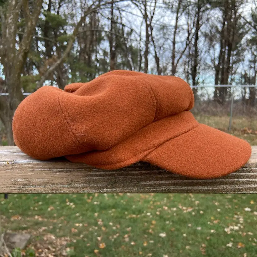 Rust-colored Newsboy Cap. 30% Wool, 70% Acrylic. Made In China.