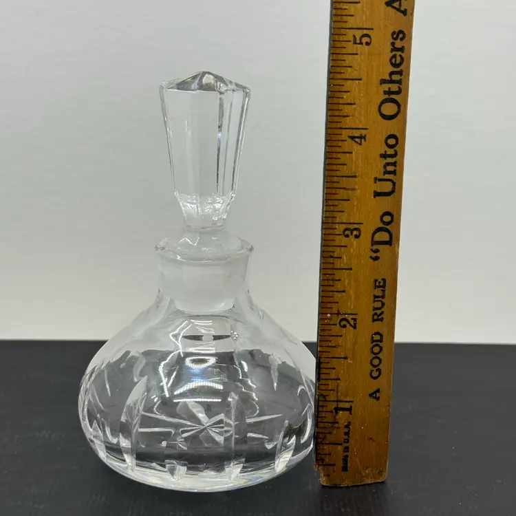 A cut crystal perfume bottle with a faceted stopper.