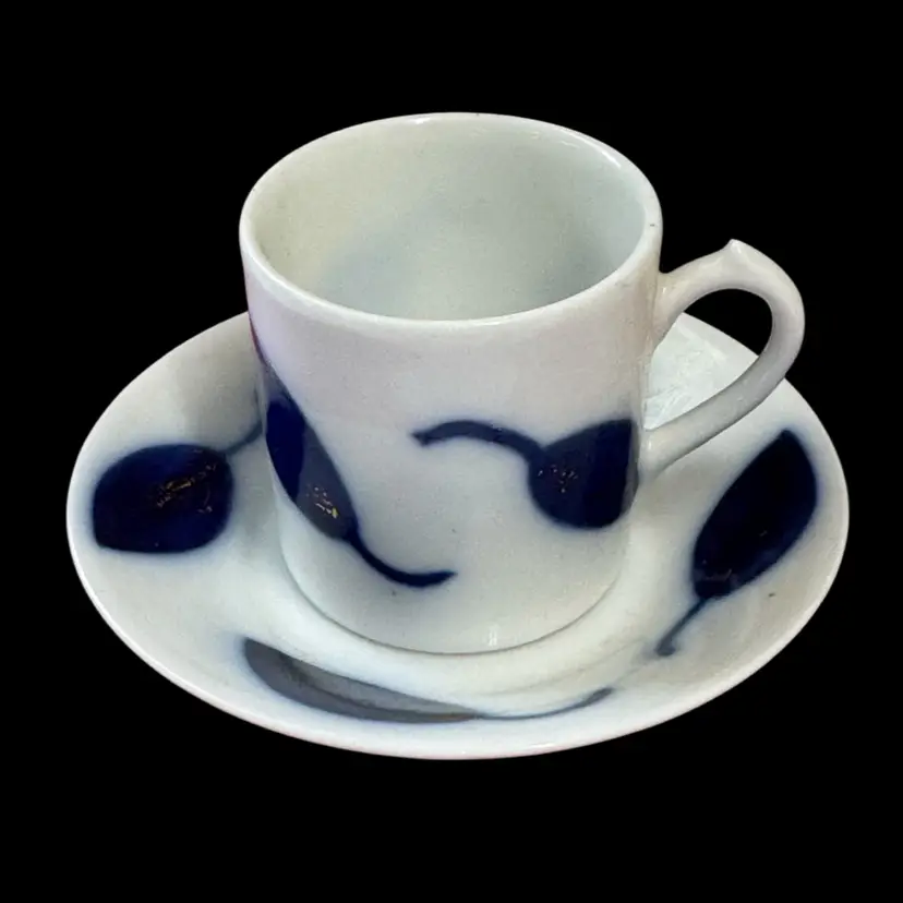 Espresso cup and saucer with abstract blue/gold leaf design.
