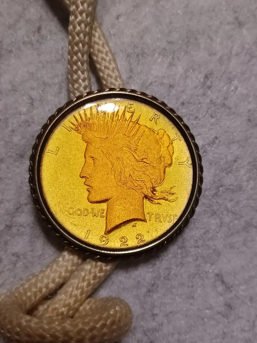 Peace Dollar coin set in gold and bolo tie