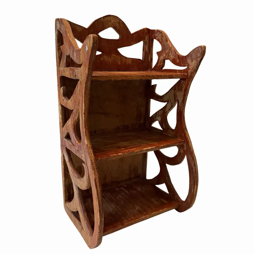 This 1930s Edwardian-style wall shelf features three tiers and intricate, ornate hand-carved fretwork sides