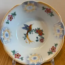 The Vintage Schwarzenhammer Bavaria Hummingbird Serving Bowl is a stunning piece of porcelain art from the mid 20th century.
Featuring a beautiful Art Nouveau style with a glossy finish and a decorative floral pattern, this 9" round bowl is perfect for serving at all occasions.
Made in Germany, this original piece showcases intricate details of a hummingbird design, adding a touch of charm to your table setting.
Hand wash only to preserve its vintage beauty.