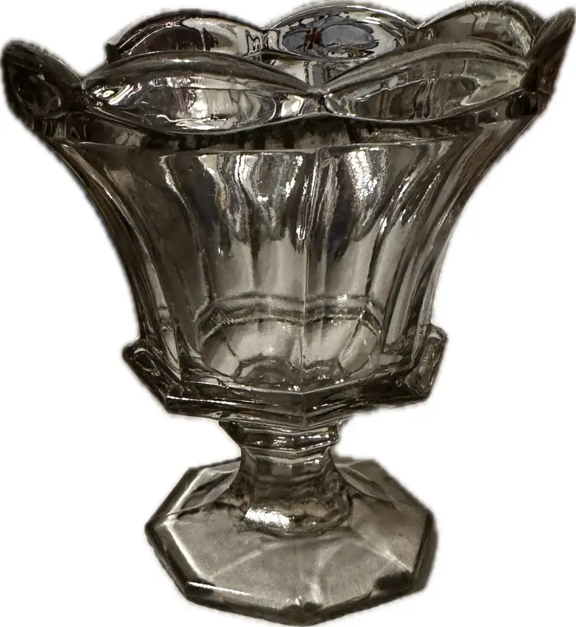 This clear, hexagonal glass pedestal bowl appears to be an antique pressed glass master salt dish from the Victorian era