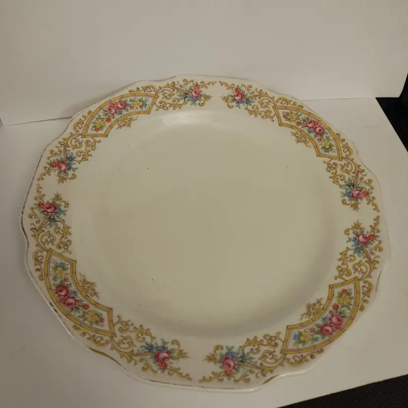 Porcelain cream plate with floral trim. 10 inch diameter. No chips or cracks.