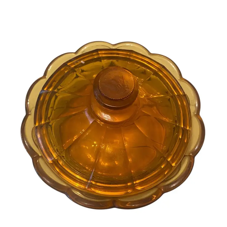 This is a vintage Fostoria Amber Coin Glass covered candy dish. It is part of the Fostoria Coin Glass collection, which was produced from 1958 to 1982