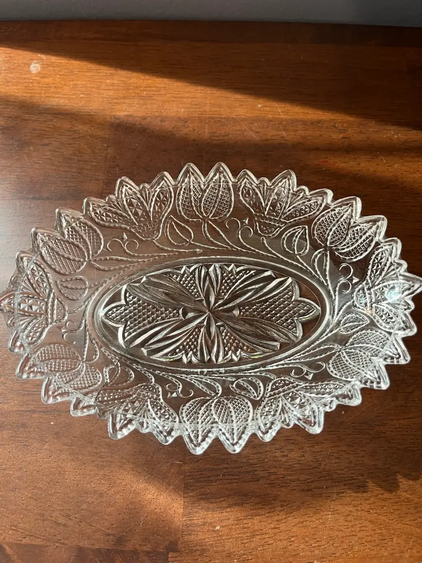 Clear pressed glass oval relish dish with embossed floral pattern. 7x5”