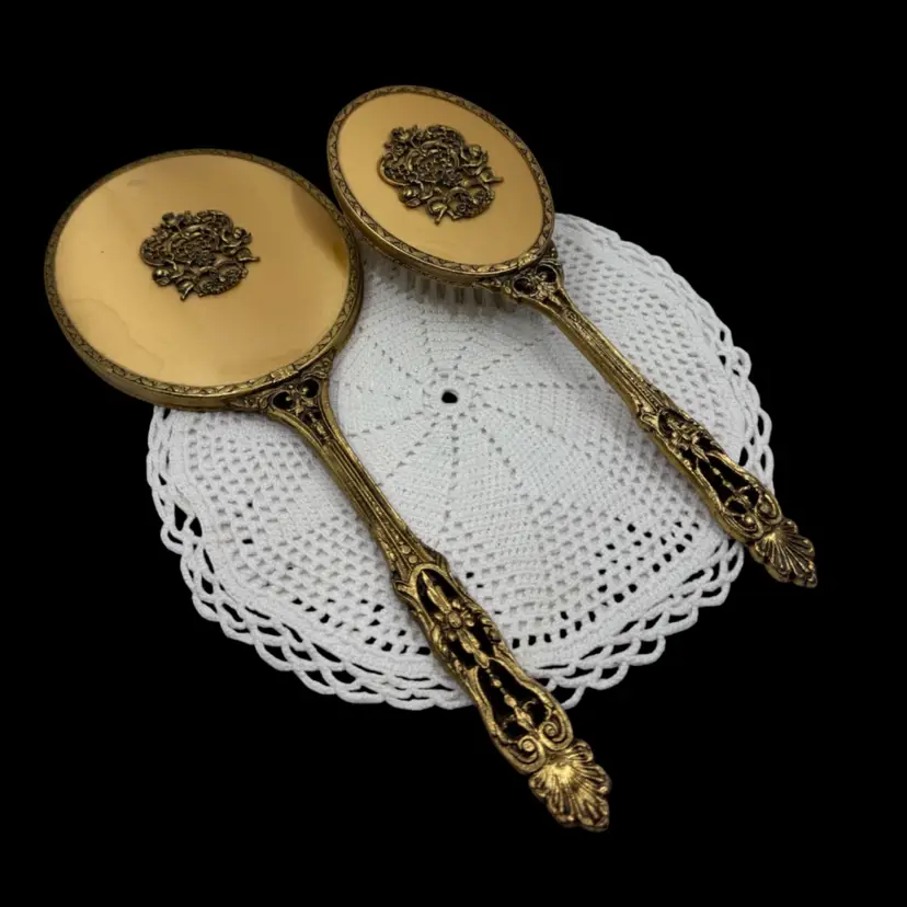 Vintage gold-plated vanity set with ornate scrollwork and floral motifs.