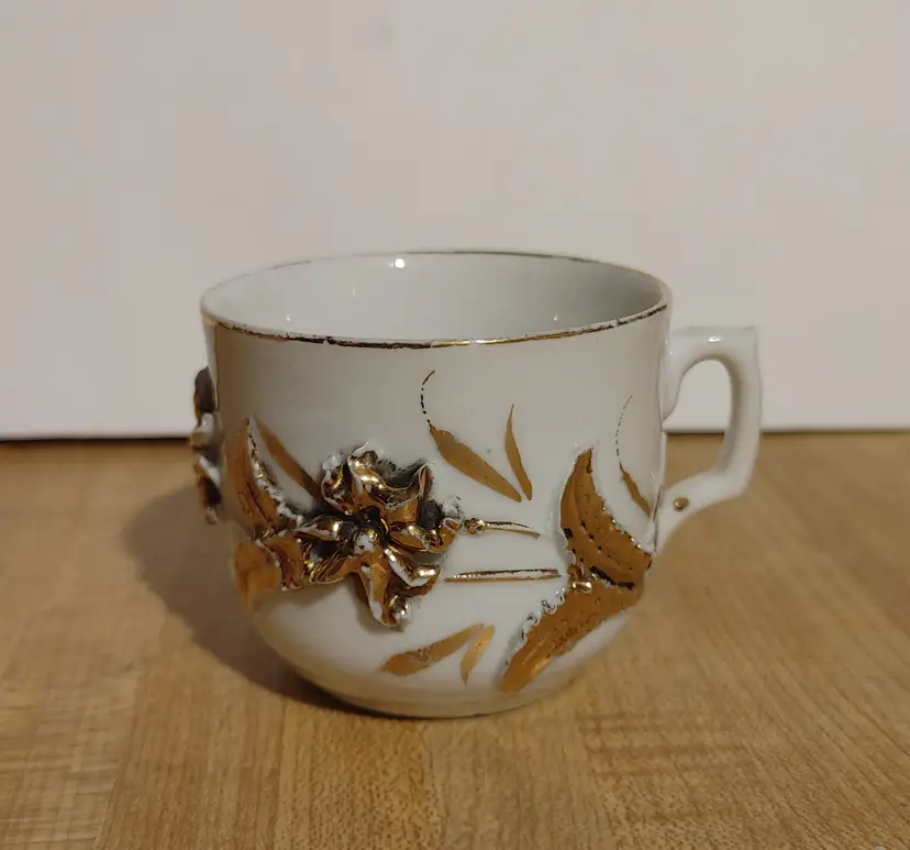 Vintage German porcelain teacup. 3D hand painted gold floral embellishments. Minor loss to gold.