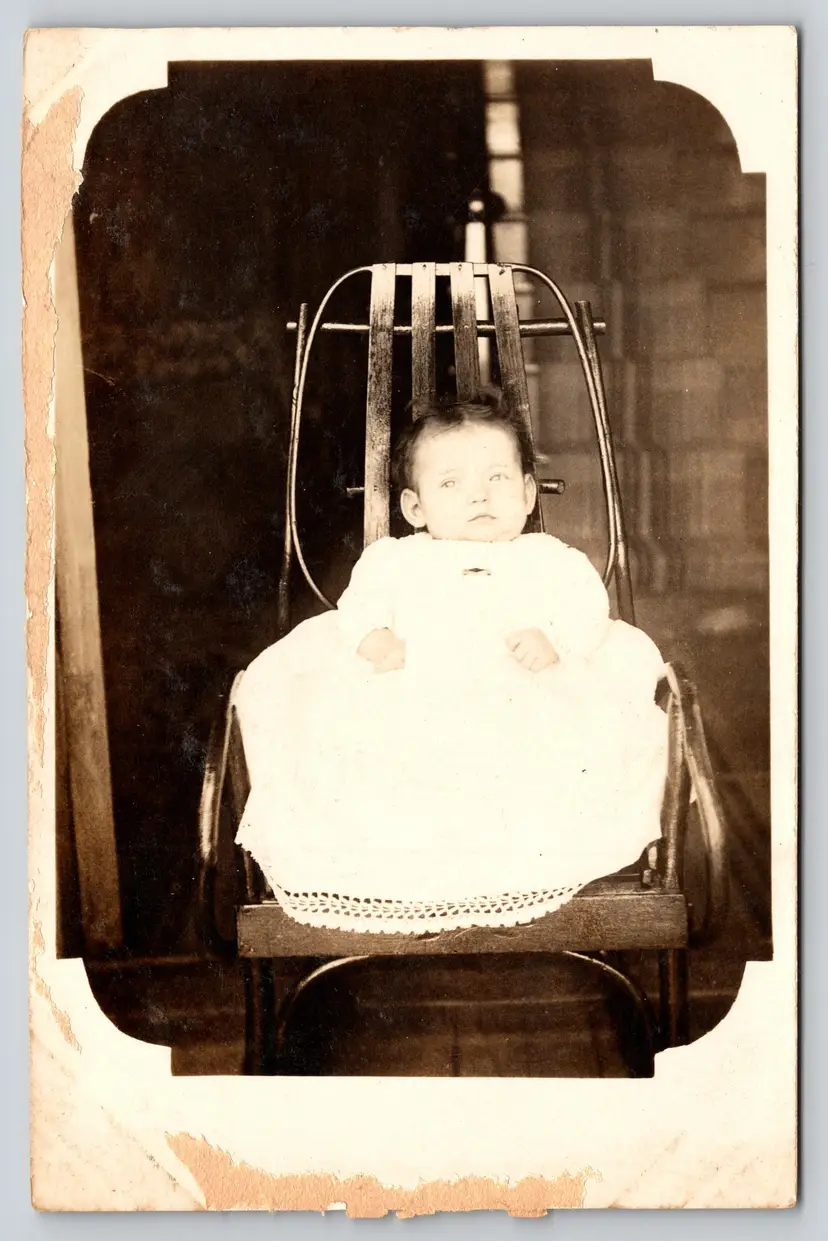 Postcard RPPC Baby in White Dress Sitting in Metal Chair Real Photo Vignette - 8754