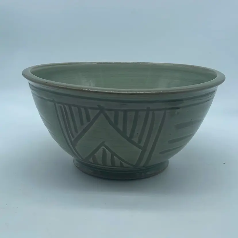 #1603 Handmade ceramic bowl with incised geometric patterns and maker's mark.