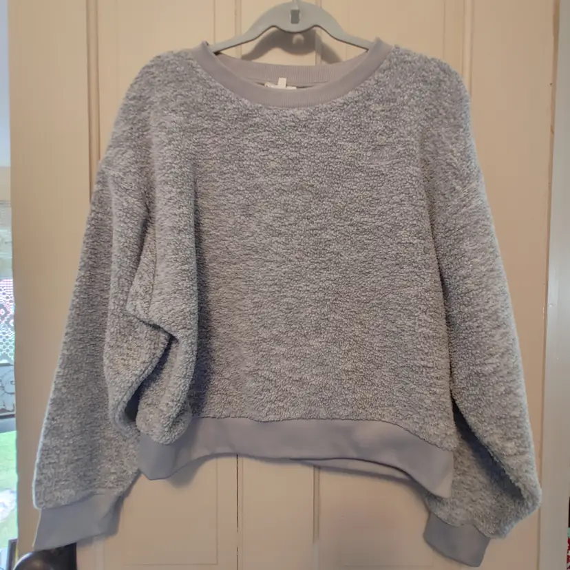 Top- Brand: Levi's. Size medium. Grey sweatshirt. Material- 100% polyester. No callouts.