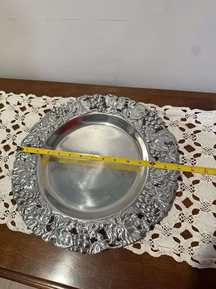 Vintage Arthur Court round tray, platter, or charger from the "Grape" collection. The piece is made of sand-cast aluminum and features a decorative border of grapes and leaves.  Measures 14”